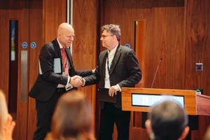 Handshake on stage, lill Global Symposium 2026, Rhodes House, Oxford